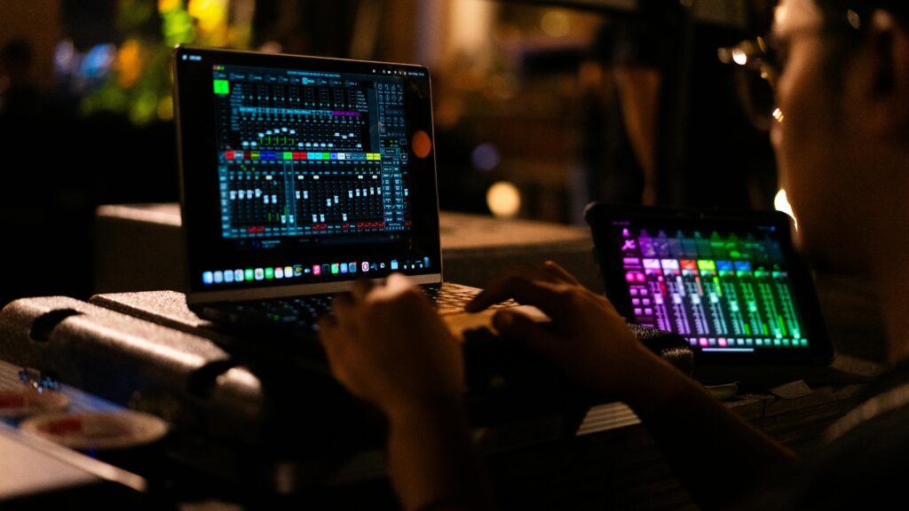 Homepage A person using digital software on a laptop for music mixing in a studio.